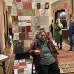 Māpura artist Ela Tukuhaukava poses in front of the quilt.